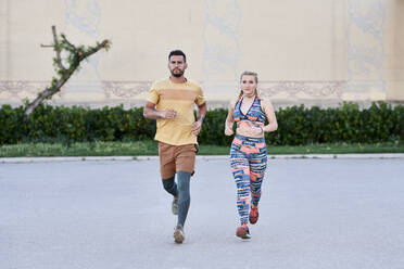 Man and woman running in the city - JNDF00086