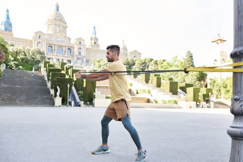 Mann bei Fitnessübungen im Freien in der Stadt - JNDF00102