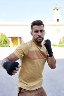 Mann beim Boxtraining im Freien in der Stadt - JNDF00106