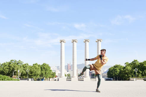 Man doing kickboxing exercise outdoors in the city - JNDF00107