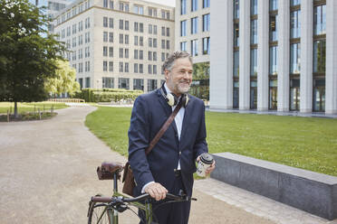 Mature businessman with bicycle in the city - RORF01848