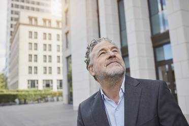 Portrait of confident businessman in the city looking up - RORF01902