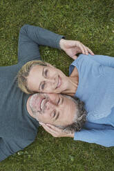 Top view of happy mature couple lying in grass - RORF01931