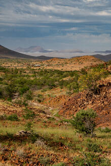 Farbenfrohe Felsenlandschaft hoch oben in den Bergen, mit Bergcamp im Hintergrund, Etendeka, Namibia, Afrika - RHPLF10313