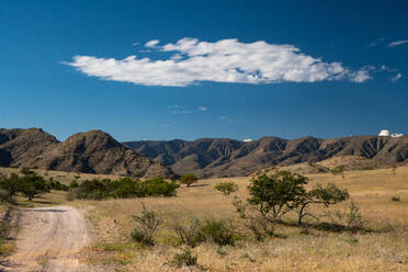 Dramatische Wolke über grüner und bergiger Landschaft, nördlich von Sesfontein, Namibia, Afrika - RHPLF10317