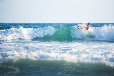 Surfer beim Surfen am Strand, Nosara, Provinz Guanacaste, Pazifikküste, Costa Rica, Mittelamerika - RHPLF10357