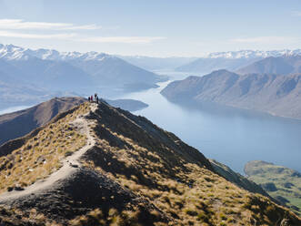 Wanderer genießen die Aussicht vom Roys Peak Wanderweg in der Nähe von Wanaka, Otago, Südinsel, Neuseeland, Pazifik - RHPLF10436