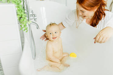 Mother with baby in bath - JOHF00410
