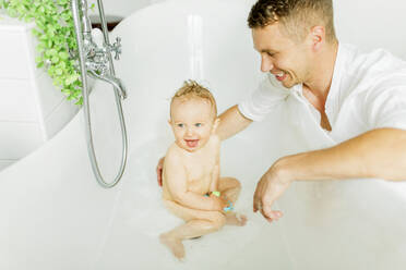 Father with baby in bath - JOHF00413