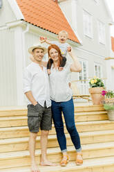 Baby boy with parents walking on steps - JOHF00523