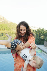 Frau spielt mit Sohn im Schwimmbad - JOHF00582