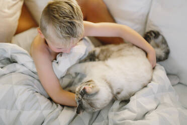 Boy with cat on sofa - JOHF00614