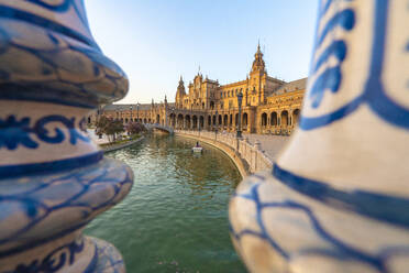 Ruderboot entlang des Kanals von den keramisch verzierten Säulen der Balustrade aus gesehen, Plaza de Espana, Sevilla, Andalusien, Spanien, Europa - RHPLF10795