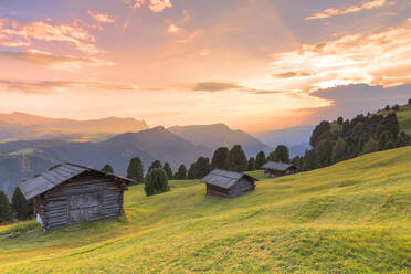Sonnenuntergang über traditionellen Hütten auf der Alm, Grödnertal, Südtirol, Dolomiten, Italien, Europa - RHPLF10895