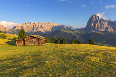 Letzte Sonnenstrahlen auf traditioneller Hütte mit Blick auf Langkofel und Sellagruppe, Grödnertal, Südtirol, Dolomiten, Italien, Europa - RHPLF10896