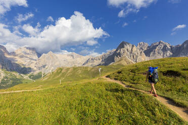 Hiker walking on a path near San Nicolo Pass, Fassa Valley, Trentino, Dolomites, Italy, Europe - RHPLF10912