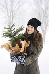 Woman with potted pine tree - JOHF00743