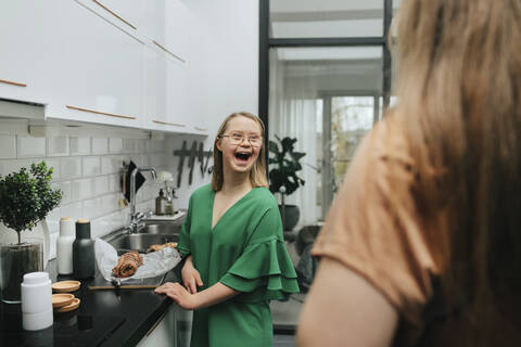 Glückliches Teenager-Mädchen in der Küche, lizenzfreies Stockfoto