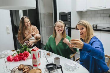 Familie am Tisch macht Selfie - JOHF00806