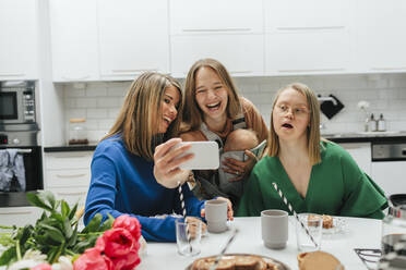 Familie am Tisch macht Selfie - JOHF00807