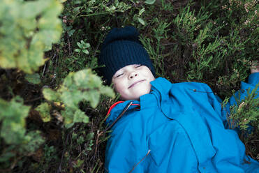 Smiling boy lying on heathers - JOHF00903