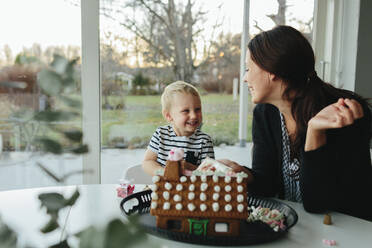 Mother with son making gingerbread house - JOHF00917