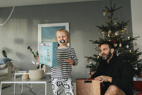 Vater mit Sohn beim Auspacken der Weihnachtsgeschenke - JOHF00920