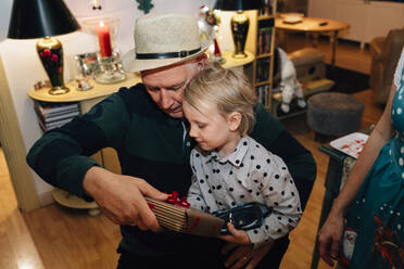 Großvater mit Enkel beim Auspacken der Weihnachtsgeschenke - JOHF00921