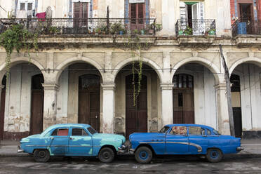 Zwei blaue Autos stehen Nase an Nase vor einem baufälligen Gebäude, Havanna, Kuba, Westindien, Karibik, Mittelamerika - RHPLF11089