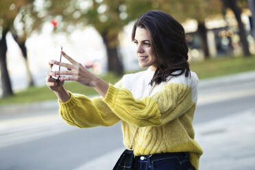 Brünette Frau macht ein Selfie in der Stadt - JSRF00563