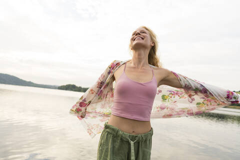 Happy young woman at a lake stock photo