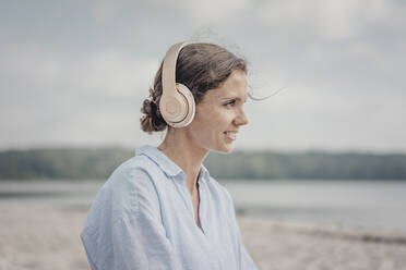 Frau hört Musik mit Kopfhörer am Meer, Poartrait - JOSF03682