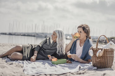 Mutter und Tochter machen ein Picknick am Strand - JOSF03694