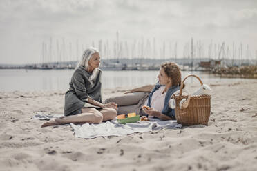 Mutter und Tochter machen ein Picknick am Strand - JOSF03696