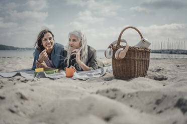 Mutter und Tochter machen ein Picknick am Strand - JOSF03760