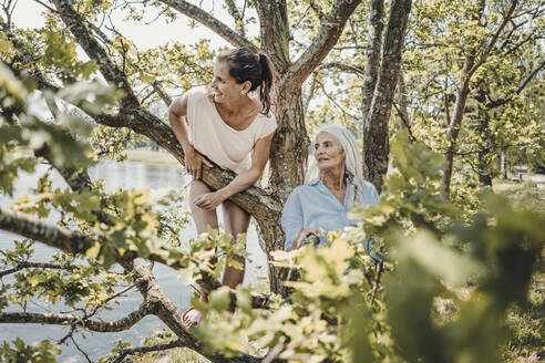 Mutter und Tochter haben Spaß, klettern auf einen Baum - JOSF03768