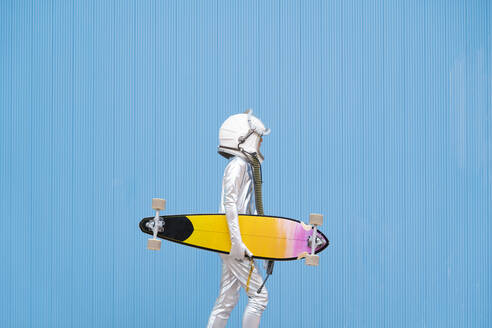 Kid dressed as an astronaut with longboard - DAMF00037