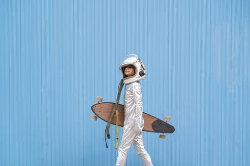 Kid dressed as an astronaut with longboard - DAMF00038