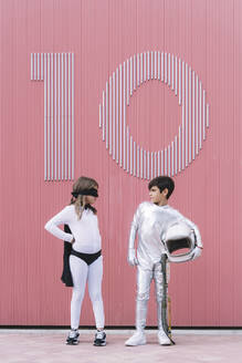 Zwei Kinder in Astronauten- und Superheldenkostümen stehen sich gegenüber - DAMF00042