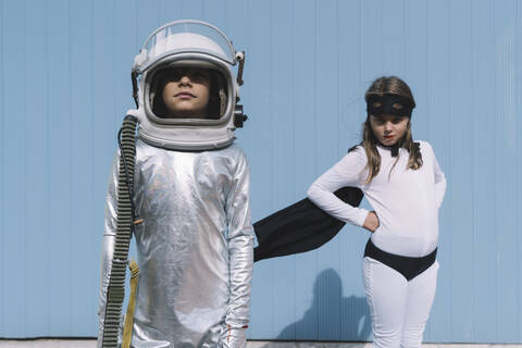 Two kids in astronaut and superhero costumes stock photo