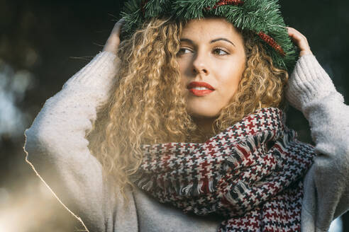 Porträt einer jungen Frau mit Weihnachtskranz auf dem Kopf - DAMF00055