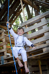 Junge als Superheld, Astronaut, der in einem Baumhaus spielt - HMEF00543