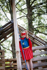 Superhero girl playing in a tree house - HMEF00562