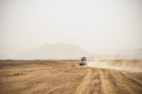 Geländewagen in einer trockenen Landschaft bei klarem Himmel an einem sonnigen Tag, Suez, Ägypten - PUF01715