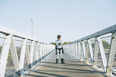 Porträt eines als Superheld verkleideten Jungen, der auf einer Fußgängerbrücke steht - JCMF00216
