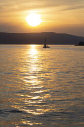 Silhouette Segelboot segeln auf dem Bodensee gegen den Himmel während des Sonnenuntergangs in Überlingen, Deutschland - FCF01803