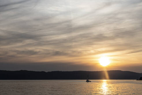 Silhouette eines Segelboots auf dem Bodensee gegen den Himmel bei Sonnenuntergang, Überlingen, Deutschland - FCF01804