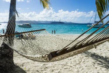 Empty hammock at beach against sky during sunny day, British Virgin Islands - RUNF03197