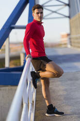 Young sportsman relaxing on a bridge - JSRF00580