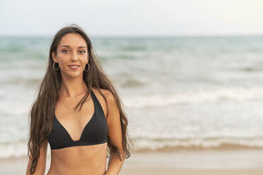 Porträt einer schönen jungen Frau im Bikini am Strand - DLTSF00138